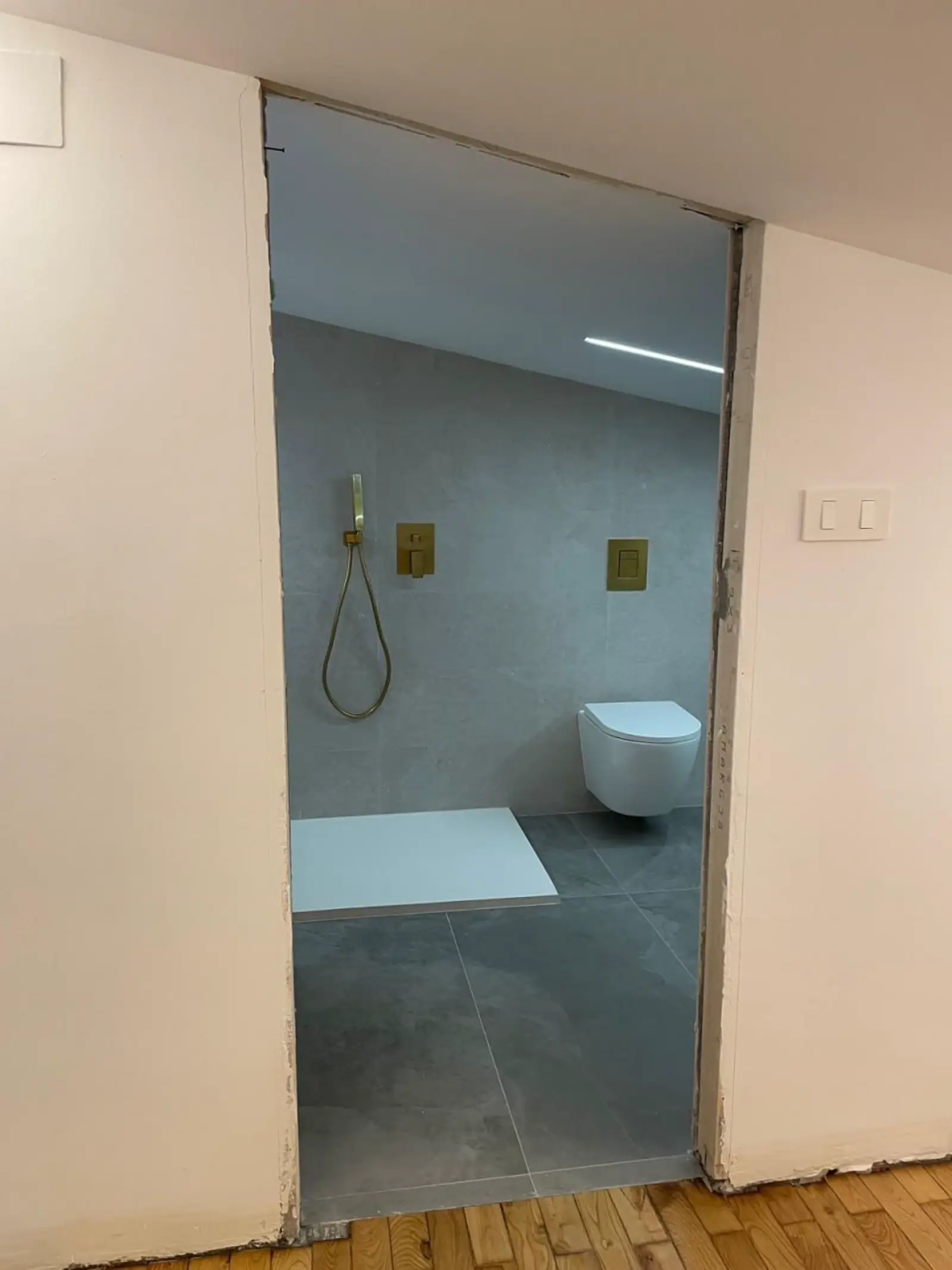 Baño en proceso de reforma con plato de ducha e instalaciones terminadas